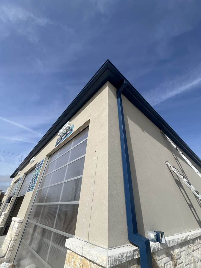 Blue seamless box gutter and downspout on a commercial building